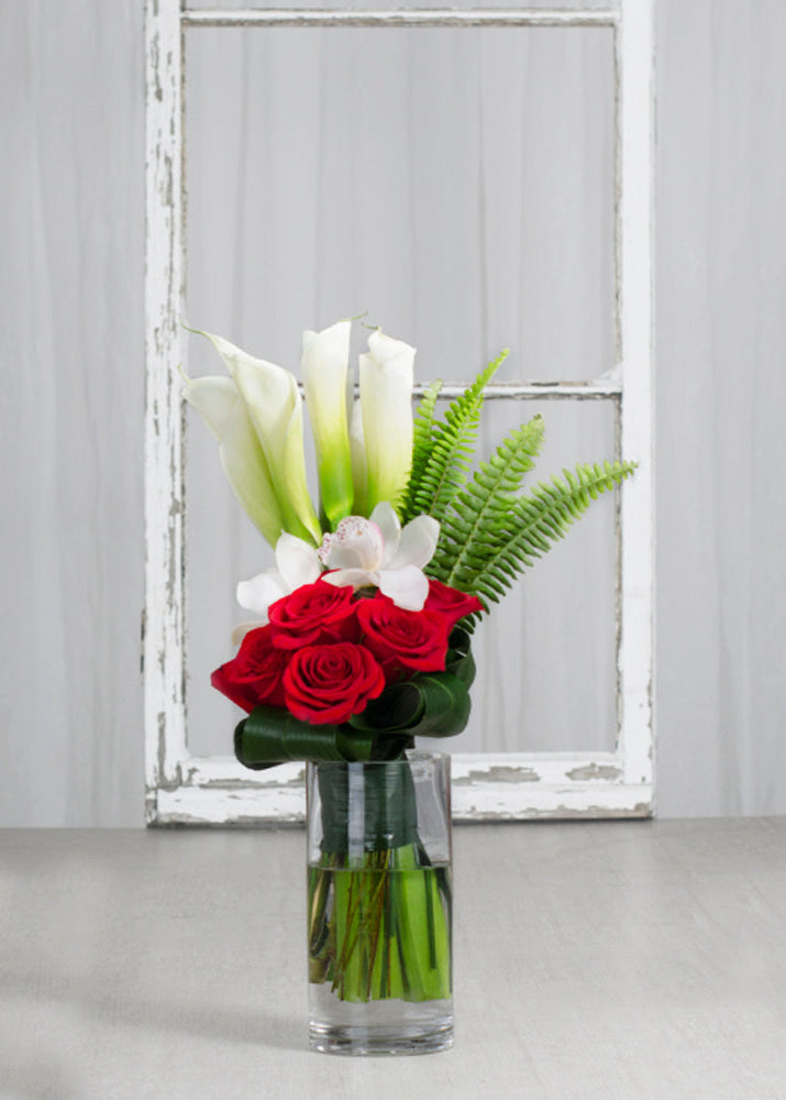 Bouquet "Élégance Passion" Deluxe avec callas blancs, roses rouges et orchidées blanches, présenté en vase transparent.