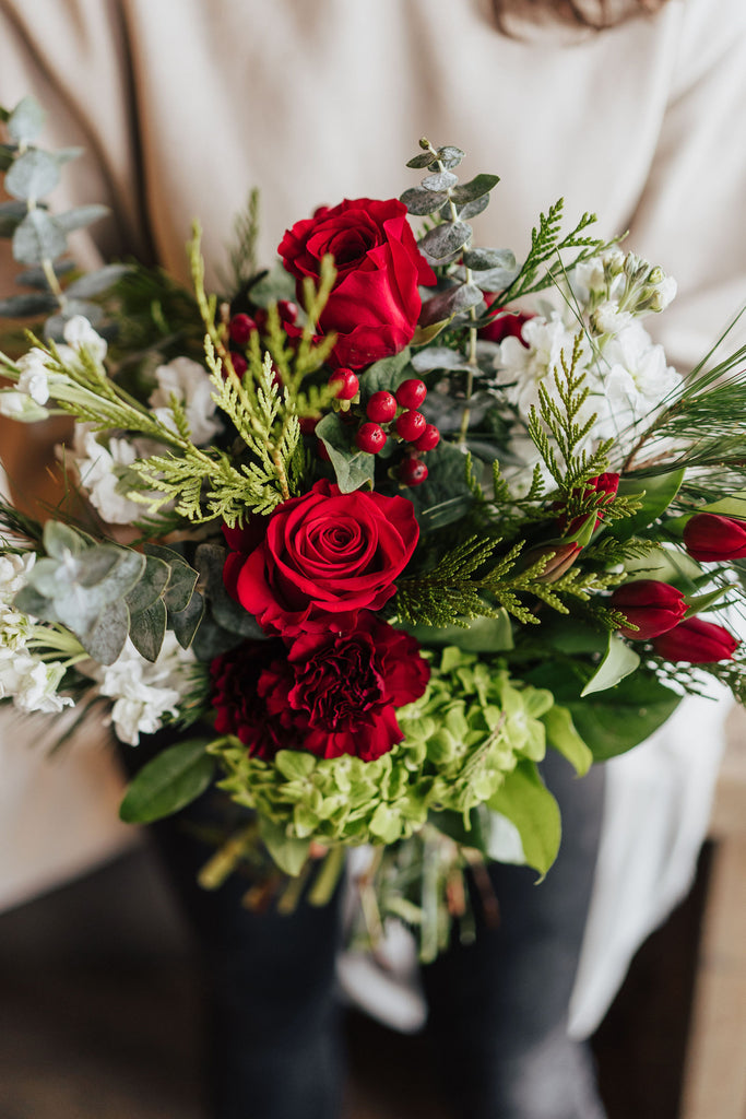 Bouquet festif rouge et vert avec roses rouges, eucalyptus et baies naturelles