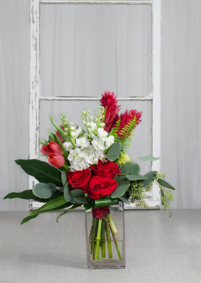 Bouquet "Ginger Passion" avec gingembre rouge, roses rouges et fleurs blanches dans un vase transparent, disponible en version classique et deluxe.