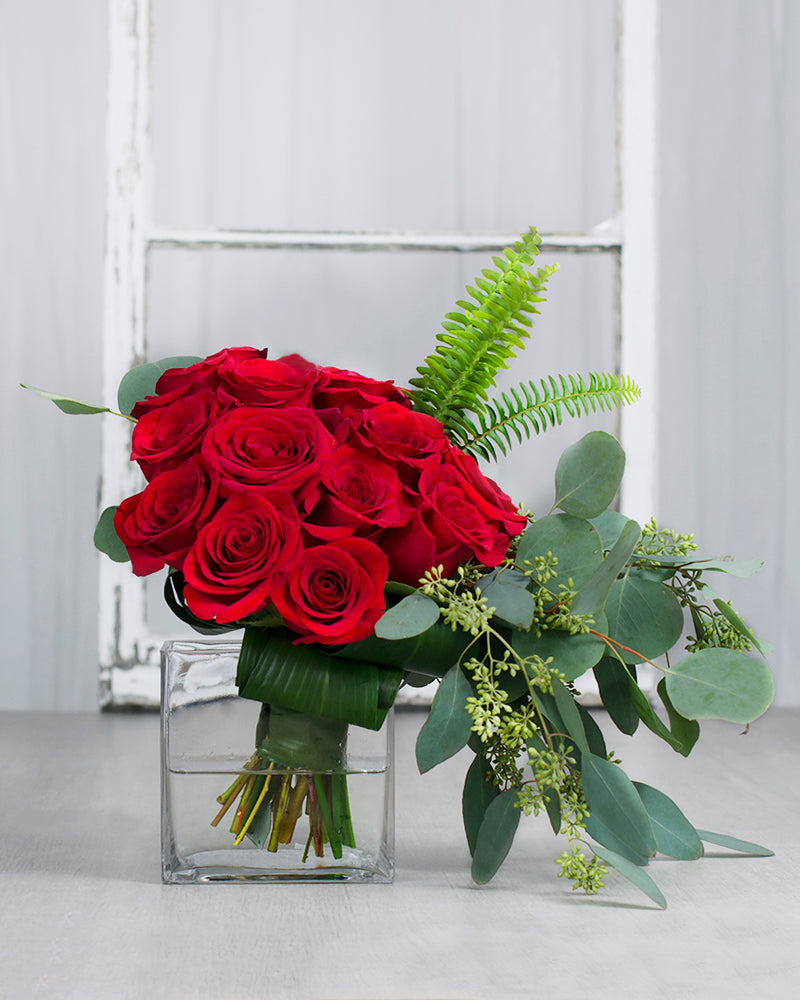 Bouquet "L'Amour à Douze Temps" avec 12 roses rouges dans un vase carré transparent, symbole d’amour passionné et intemporel.