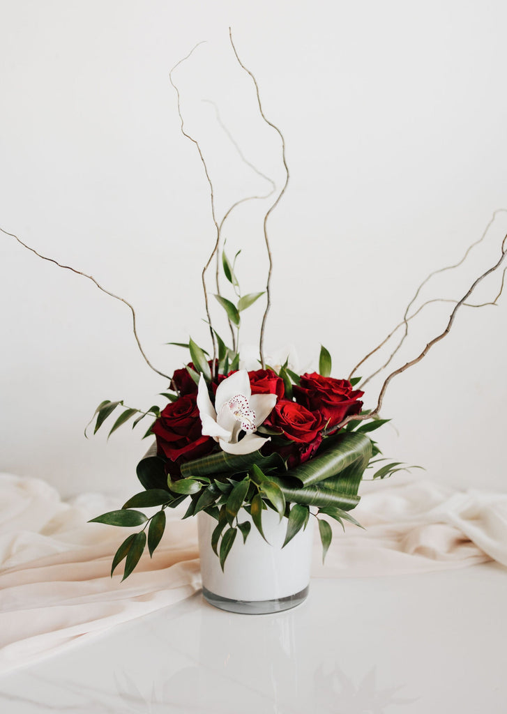 Bouquet "Romance" avec roses rouges et orchidées blanches dans un vase élégant, réalisé dans la mousse florale.