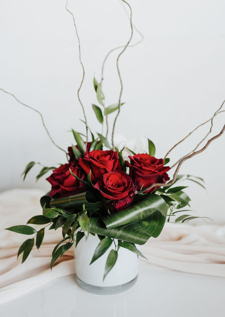 Bouquet "Romance" avec roses rouges et verdures dans un vase élégant, réalisé dans la mousse florale.