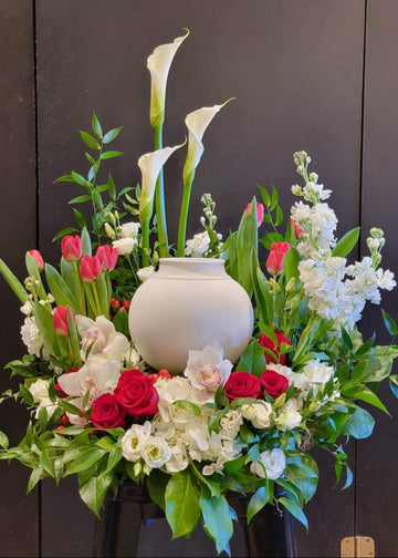 Arrangement floral funéraire avec callas, roses et urne blanche